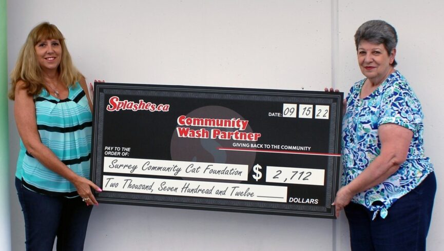 two member of surrey cats holding a cheque of two thousand seven hundred and twelve dollars