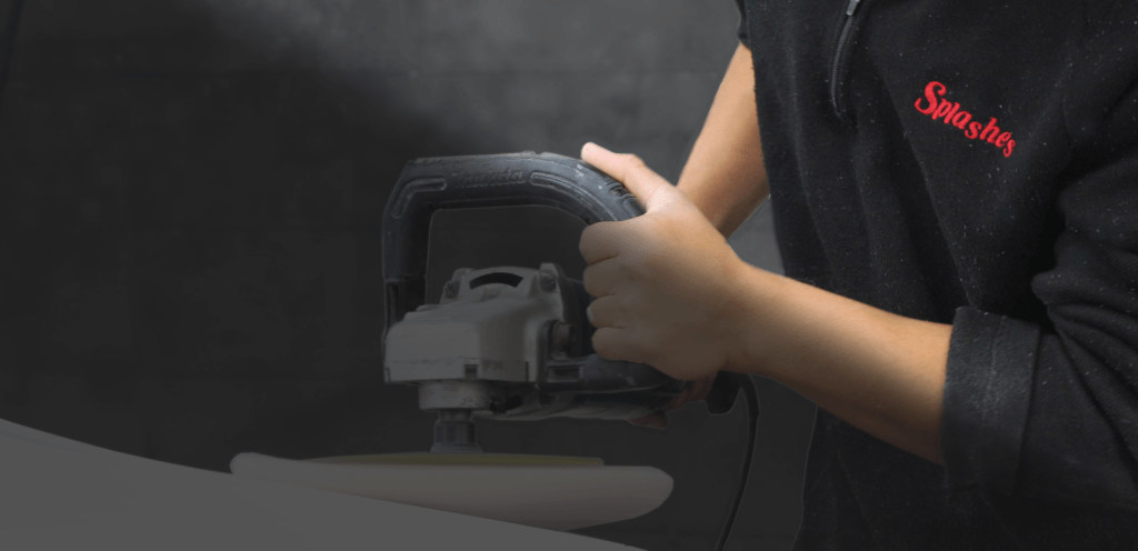 two hands holding a polish tool while polishing a white car