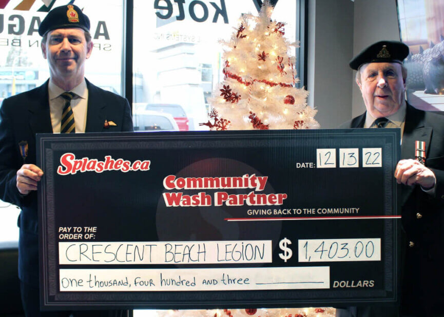 two members of legion holding a cheque of one thousand four hundred and three dollars