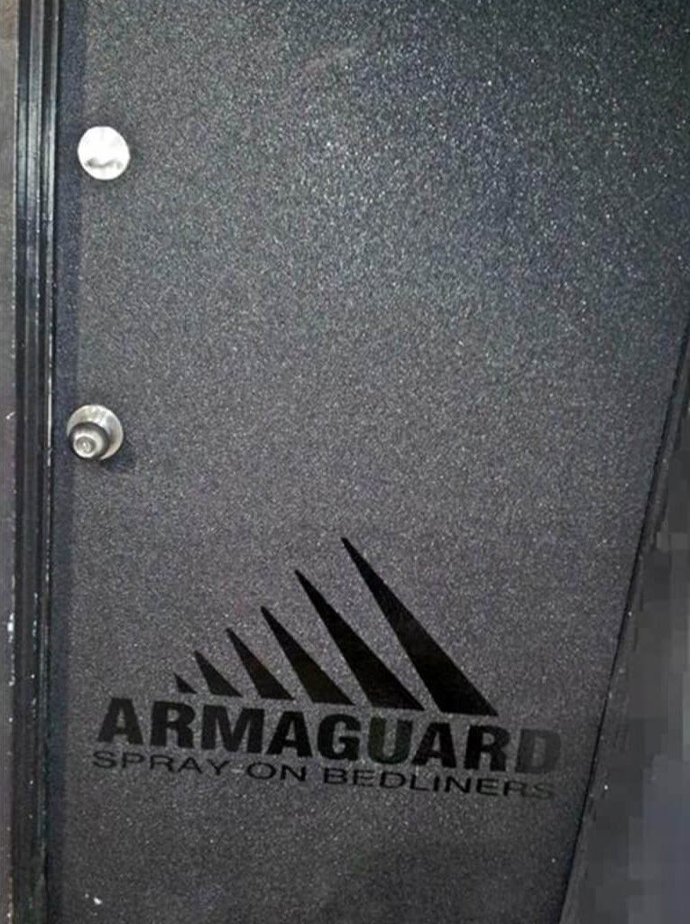 grey door with armaguard bedliner spray on it and the armaguard logo
