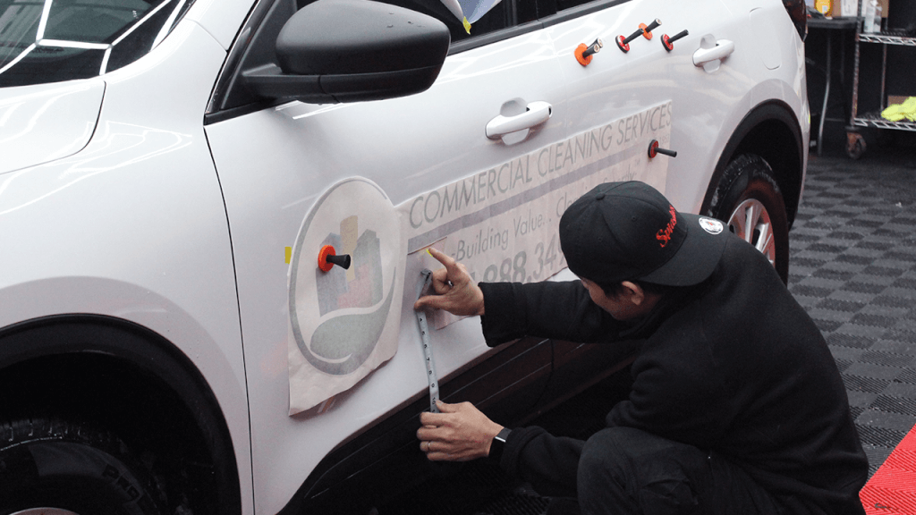 commercial decal being installed on the car